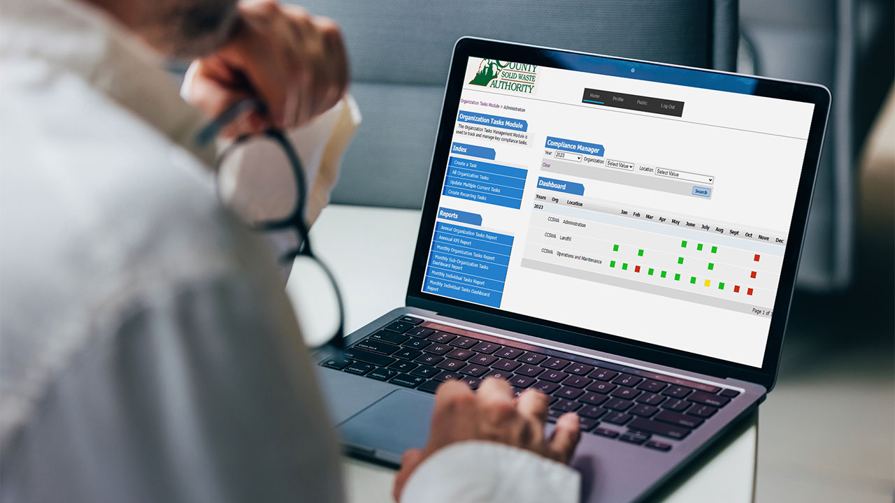 A person looking at a laptop with the Compliance Calendar Manager Module dashboard on screen